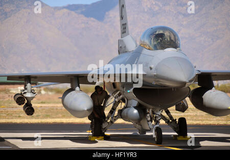 Senior Airman e il capo dell'equipaggio del 177th Fighter Wing, New Jersey Air National Guard, eseguono i controlli di sicurezza finali sotto l'ala di un F-16D Fighting Falcon presso la Davis-Monthan Air Force base, Arizona, il 26 febbraio 2014, preparando il velivolo per il lancio durante l'operazione Snowbird. Foto Stock