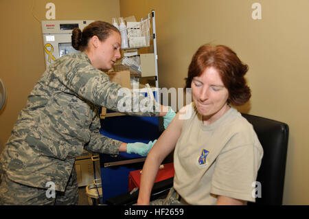 Stati Uniti Air Force 1 Lt. Lindsay Chapman, Medical Group, 181st ala di intelligence, Indiana Air National Guard vaccinati Master Sgt. Rhonda Howell con il vaccino MMR (Morbillo, Parotite e Rosolia) durante il maggio 2014 Unità gruppo di formazione in campo Hulman, Terre Haute, ind. Mantenere la disponibilità di missione è la chiave per l'Intelligenza 181st ala e la Air National Guard. (U.S. Air National Guard foto di Senior Master Sgt. John S. Chapman/RILASCIATO) Missione pronto 140518-Z-PM441-287 Foto Stock
