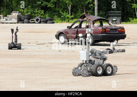 Due robot, compreso quello utilizzato dai membri del 202nd l'eliminazione degli ordigni esplosivi Company, 201st regionale gruppo di supporto, prendere i diversi punti di vista per guardare un auto durante un post-blast scenario durante il quarto giorno di corvi sfida VIII, una a livello nazionale esercizio di interoperabilità con diversi enti federali e statali ospitato dall'Ufficio di presidenza di alcol, tabacco e armi da fuoco. (Georgia esercito nazionale Guard foto di Sgt. Chris Stephens) 202nd EOD 'suits fino' in Alabama 140630-Z-WV152-131 Foto Stock