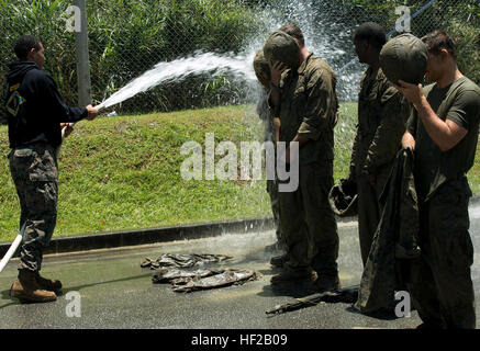 Corpsmen ed avieri vengono spruzzati con acqua per pulire il fango accumulato Luglio 20 dopo il combattimento Endurance ovviamente il test finale della giungla medicina Corso di combattimento alla guerra nella giungla del Centro di Formazione su Camp Gonsalves. Il corpsmen resistito a quattro miglia di ostacoli e navigato attraverso la simulazione di situazioni di combattimento nella giungla del terreno. Il servizio i membri sono anche spruzzata per rinfrescarsi dopo aver eseguito il corso per ore sotto il sole di Okinawa. Il corpsmen sono con 3° Battaglione dentale e 3° Battaglione medico, entrambi con terzo Marine Logistics Group, III Marine forza expeditionary; nonché 1 s Foto Stock