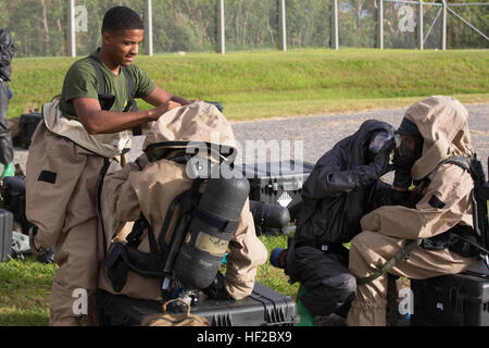 Stati Uniti Marine, chimica radiologica biologiche nucleari (CBRN) specialisti di difesa dal 31 Marine Expeditionary Unit condurre un esercizio di formazione su Camp Hansen, Okinawa, in Giappone il 30 luglio 2014. CBRN è affidata la missione di individuare, test e contengono materiali pericolosi o di gas per proteggere ulteriormente U.S. Le forze. (U.S. Marine Corps Photo by Lance Cpl. Brian Bekkala/ Rilasciato) 31 MEU Marines tuta per esercizio CBRN 140730-M-GR217-245 Foto Stock