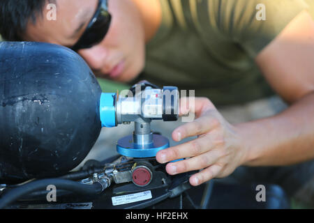 Stati Uniti Marine Corps Cpl. Jon R. Loftus, Team Leader per recon team uno, con agenti chimici, biologici, radiologici e nucleari, plotone di 1 aeromobili Marina Wing attribuisce il suo serbatoio di ossigeno e la sua missione orientata postura protettiva insieme durante un incidente pericoloso risposta esercizio di formazione su Marine Corps Air Station Futenma, Okinawa, in Giappone, e il agosto 27, 2014. La formazione è stata condotta come parte di Ulchi Freedom Guardian 14, un combinato di esercitazione militare tra la Corea del Sud e gli Stati Uniti per aiutare Marines pratica casualty di evacuazione e la decontaminazione di individui nel contaminare chimicamente Foto Stock