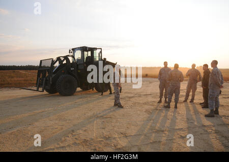 Trasporto aeree specialisti assegnati per il 193rd Operazioni Speciali Disponibilità Logistica Squadron, Middletown Pa., membri del lituano di Air Force, e da un membro del lettone Air Force di attendere al campo di Coyle aeroporto, Chatsworth, N.J., Sett. 18, 2014, contenitore per i sistemi di erogazione per essere lasciato cadere da una CE-130J Hercules aeromobili. Membri della Lituania e Lettonia forze dell'aria addestrati con 193rd SOLRS come parte di Pennsylvania-Lithuania Guardia Nazionale dello stato del programma di partenariato. (U.S. Air National Guard foto di Tech. Sgt. Culeen Shaffer/RILASCIATO) Carrello 140918 formazione-Z-HT970-019 Foto Stock