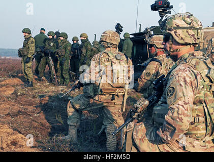 Soldati assegnata al 1° Brigata Team di combattimento, 1° Divisione di cavalleria, e i loro partner alleati assegnato al lituano di forze armate di attendere a bordo dei loro veicoli prima di partecipare a un combinato di bracci live-fire esercizio che ha dimostrato comune capacità di fuoco e la manovra attraverso linee di cottura in un'installazione militare nei pressi di Pabrade, Lituania, Ottobre 30, 2014. Queste attività sono parte dell'U.S. Esercito Europa-Funzionamento led Atlantic risolvere forze terrestri formazione assicurazione luogo in tutta l'Estonia, la Lettonia, la Lituania e la Polonia per migliorare l'interoperabilità multinazionale, rafforzare la relazione Foto Stock