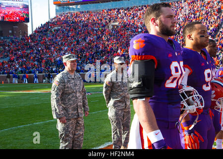 Carolina del Sud la Guardia Nazionale di capo del personale, Col. James 'Ronnie' Finley e Staff Sgt. Eric Bamberg, una società, 151st segnale Expeditionary battaglione, unisciti al team i comandanti sul campo per il coin toss. Università di Clemson onorato servizio corrente i membri e i veterani durante il militare apprezzamento del gioco del calcio nov. 22, 2014, contro lo Stato della Georgia. (U.S. Esercito nazionale Guard photo by Staff Sgt. Erica Knight/RILASCIATO) Clemson onori militari e Vietnam Veterans 141122-Z-DH163-077 Foto Stock