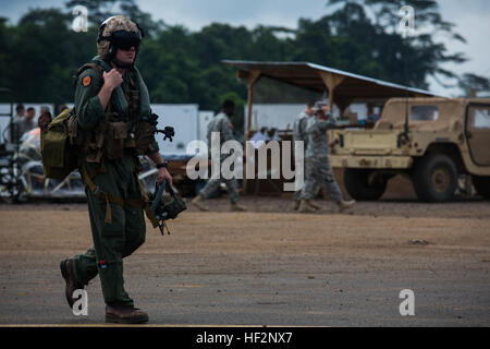 Stati Uniti Marine Corps Capt. Joshua Jelosek, un pilota con SPMAGTF risposta in caso di crisi - Africa cammina verso una MV-22B Osprey prima battenti la loro ultima missione a sostegno del funzionamento assistenza unita a Monrovia, Liberia, 1 dicembre, 2014. Regno assistenza è un Dipartimento della Difesa il funzionamento per fornire il comando e il controllo della logistica e della formazione e il supporto tecnico di U.S. Agenzia per lo Sviluppo Internazionale- ha guidato gli sforzi per contenere il virus Ebola focolaio nella zona ovest di nazioni africane. (U.S. Marine Corps photo by Lance Cpl. Andre Dakis/SP-MAGTF-CR-AF Combattere la telecamera/RILASCIATO) Marines americani completa due mesi Foto Stock