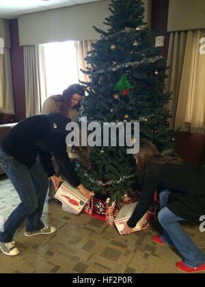 Icy Munchel, sinistra, Megan Goold, centro e Katie Contento hanno luogo i pacchetti di cura sotto un albero di Natale al Marine Corps Air Station Cherry Point, N.C., Dicembre 3, 2014. Membri della In-Service Centro di assistenza con la disponibilità di flotta Center East a Cherry punto donato più di 118 pacchetti di cura a Marines e marinai con antenna Marine Refueler squadrone di trasporto 252. I pacchetti contenuti articoli da toeletta, gli elementi di comfort e video giochi. Munchel è la famiglia disponibilità ufficiale con VMGR-252; Goold è un chimico con Naval Air Systems Command; e Conento è un T-64 ingegnere con NAVAIR. Cherry Point ci Foto Stock