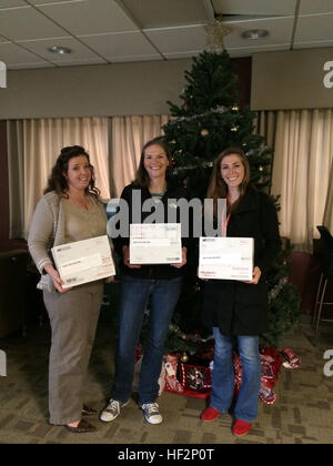 Icy Munchel, sinistra, Megan Goold, centro e Katie Contento pongono di fronte a un albero di Natale al Marine Corps Air Station Cherry Point, N.C., 6 dicembre 2014. Il In-Service Support Center team di attività ha donato più di 118 pacchetti di cura a Cherry Point Marines e marinai distribuito a Moron, Spagna Con Marine antenna squadrone di trasporto 252. Munchel è la famiglia disponibilità ufficiale con VMGR-252; Goold è un chimico con Naval Air Systems Command; e Conento è un T-64 ingegnere con NAVAIR. Cherry Point civili invia pacchetti di cura su distribuito Marines, marinai 141203-M-GY210-502 Foto Stock