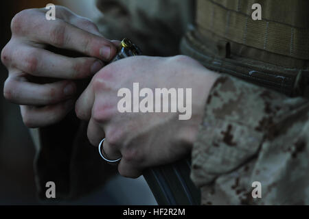 Un Marine con il plotone di sicurezza marittima forza Raid, 24 Marine Expeditionary Unit, carichi di 5,56 mm giri in una rivista durante un live-fire sparare sul ponte di volo della USS Iwo Jima, Dic 19, 2014. Il ventiquattresimo MEU distribuito la scorsa settimana a un flessibile, mare-forza di base con il compito di fornire la risposta alle crisi in tutta la gamma delle operazioni militari, da conflitti armati all'assistenza umanitaria. (U.S. Marine Corps photo by Lance Cpl. Dani Zunun) 2015 Settimana di distribuzione 1 141219-M-WA276-005 Foto Stock