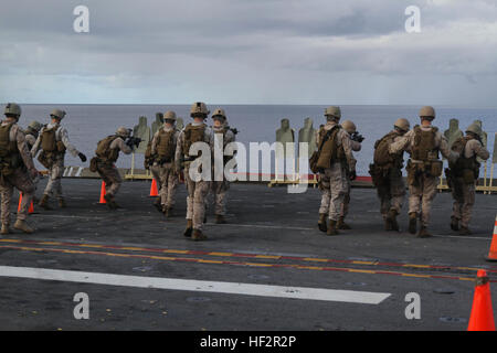 Marines con il plotone di sicurezza marittima forza Raid, 24 Marine Expeditionary Unit, fuoco le loro armi durante un live-fire sparare sul ponte di volo della USS Iwo Jima, Dic 19, 2014. Il ventiquattresimo MEU distribuito la scorsa settimana a un flessibile, mare-forza di base con il compito di fornire la risposta alle crisi in tutta la gamma delle operazioni militari, da conflitti armati all'assistenza umanitaria. (U.S. Marine Corps photo by Lance Cpl. Dani Zunun) 2015 Settimana di distribuzione 1 141219-M-WA276-008 Foto Stock