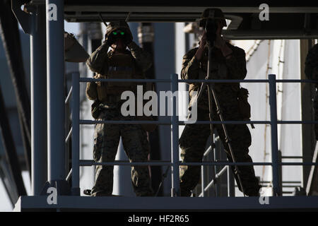 La Scout snipers con armi Company, Battaglione Team di atterraggio 3° Battaglione, 6° Reggimento Marini, 24 Marine Expeditionary Unit, osservare le navi nelle vicinanze mentre a bordo della USS Iwo Jima, in mare, Dic 27, 2014. L'Iwo Jima era in transito attraverso lo Stretto di Gibilterra. Il ventiquattresimo MEU e Iwo Jima Amphibious Ready Group stanno conducendo operazioni militari negli Stati Uniti Sesta flotta area di operazioni a sostegno degli Stati Uniti per gli interessi di sicurezza nazionali in Europa. (U.S. Marine Corps photo by Lance Cpl. Dani A. Zunun) USS Iwo Jima capi nel Mediterraneo 141227-M-WA276-061 Foto Stock