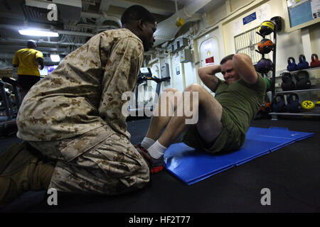 Caporale Steven D. Riggan, a destra, un tecnico di munizioni con la XXIV Marine Expeditionary dell'unità di elemento di comando esegue un sit up durante il benessere fisico porzione di un meritorio sergente promozione della concorrenza a bordo della USS Iwo Jima, Gennaio 18, 2015. Il ventiquattresimo MEU è imbarcata sulle navi di Iwo Jima anfibio gruppo pronto e distribuito per mantenere la sicurezza regionale negli Stati Uniti Quinta Flotta area di operazioni. (U.S. Marine Corps photo by Lance Cpl. Austin A. Lewis) meritorio Sgt. Bordo di mare 150118-M-QZ288-160 Foto Stock