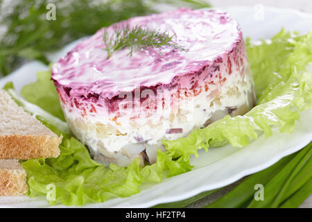 Insalata "aringa sotto una pelliccia"su una piastra bianca Foto Stock