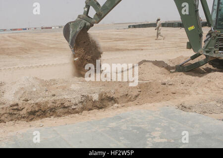 090426-M-8478B-002.jpg CAMP BASTION, provincia di Helmand, Repubblica Islamica dell'Afghanistan - un retroescavatore badili e di sporco rock fuori da una fossa di scarico costruito per supportare il nuovo aeromobile di espansione parcheggio 26 aprile 2009, a Camp Bastion, provincia di Helmand, Repubblica Islamica dell'Afghanistan. I marines della Marina Wing Support Squadron 371 hanno iniziato la costruzione di 1.9 milioni di piedi quadrati di parcheggio degli aeromobili espansione che fornirà agli aerei militari di un posto per parcheggiare dopo lo sbarco al Camp Bastion airfield, un servizio attualmente non disponibile. MWSS-371 è parte dell'aviazione elemento di combattimento della seconda Marin Foto Stock