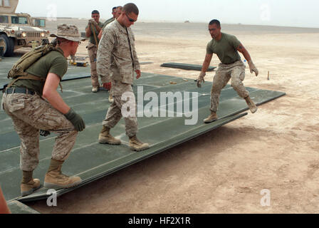 090429-M-8478B-034.jpg CAMP BASTION, provincia di Helmand, Repubblica Islamica dell'Afghanistan - Lance Cpl. Byron verde, Cpl. Benjamin Dube e Sgt. Timothy Cannella stendere un foglio di alluminio, o AM-2, matting 26 aprile 2009, a Camp Bastion, provincia di Helmand, Repubblica Islamica dell'Afghanistan. I marines della Marina Wing Support Squadron 371 hanno iniziato la costruzione di 1.9 milioni di piedi quadrati di parcheggio degli aeromobili espansione che fornirà agli aerei militari di un posto per parcheggiare dopo lo sbarco al Camp Bastion airfield, un servizio attualmente non disponibile. Marines di tutti militari specialità professionale, mento Foto Stock