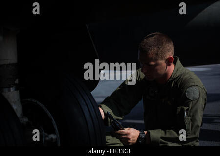 Stati Uniti Marine Corps Cpl. Matteo Ramos, aviazione meccanico, attacco Marino Squadron (VMA) 231(-), 31 Marine Expeditionary Unit (MEU), conduce operazioni di manutenzione su un AV-8B Harrier appartenenti a VMA-231(-) sul ponte di volo della USS Bonhomme Richard (LHD 6) durante l'esercizio di certificazione (CERTEX), al mare, 16 marzo 2015 CERTEX è la valutazione finale del trentunesimo MEU/Bonhomme Richard anfibio gruppo pronto per loro regolarmente pianificate pattuglia di primavera della regione Asia-Pacifico. (U.S. Marine Corps photo by Lance Cpl. Richard Currier/RILASCIATO) Harrier manutenzione 150316-M-UH847-010 Foto Stock