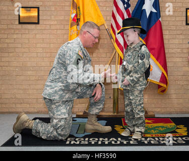 Il comando Sgt. Il Mag. Mark A. Weedon, Texas forze militari arruolati senior adviser, monete Rowan Windham. Windham honorarily fu arruolato nell'esercito del Texas la guardia nazionale a una cerimonia di premiazione che si terrà a Camp Mabry di Austin in Texas, 27 marzo 2015. Windham sta combattendo una malattia rara, Shwachmann-Diamond sindrome, che interessa il pancreas, gastro-intestinale, il sistema immunitario, sangue e midollo osseo. Durante uno dei suoi soggiorni presso l'Ospedale per bambini in San Antonio, Windham incontrato Sgt. David Hixson, un medic con il Texas Esercito nazionale di protezione. Lì, Windham condiviso il suo sogno di sempre desiderosi di essere un soldato Foto Stock