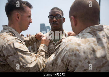 150402-M-YH418-007: Golfo di Aden (2 aprile 2015) - Michael Johnson, un militare di funzionario di polizia con le forze di distacco, 24 Marine Expeditionary Unit, è promosso a caporale a bordo il trasporto anfibio dock nave USS New York (LPD 21), 2 aprile 2015. Il ventiquattresimo MEU è imbarcata sulle navi di Iwo Jima anfibio gruppo pronto e distribuito per mantenere la sicurezza regionale negli Stati Uniti Quinta Flotta Area di operazioni. (U.S. Marine Corps foto di Cpl. Todd F. Michalek/RILASCIATO) CLB 24 promozioni in mare 150402-M-YH418-007 Foto Stock