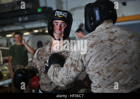 Lancia Cpl. Daniel Mills, un rifleman con Lima Company, Battaglione Team di atterraggio 3° Battaglione, 6° Reggimento Marini, 24 Marine Expeditionary Unit, si prepara a lanciare un punzone durante un pieno contatto sessione sparring come parte della cintura verde durante la certificazione Marine Corps Arti Marziali training del programma a bordo dell'assalto anfibio nave USS Iwo Jima (LHD 7), 10 aprile 2015. Il ventiquattresimo MEU è imbarcata su Iwo Jima anfibio gruppo pronto e distribuito per mantenere la sicurezza regionale negli Stati Uniti Quinta Flotta area di operazioni. (U.S. Marine Corps photo by Lance Cpl. Dani A. Zunun/RILASCIATO) Marines americani continu Foto Stock