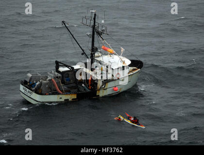 KODIAK, Alaska - Aviazione tecnico di sopravvivenza prima classe Chuck Ferrante, un crewman da un MH-60 Jayhawk elicottero dalla stazione aria Kodiak in bilico sopra, afferra un lifering e due kayak come equipaggio del peschereccio per traino vigile di lui verso la nave di prendere il weathered kayakers a bordo di luglio 30, 2009. L'equipaggio trova i due uomini dopo una ricerca nei pressi di Gore punto a circa 40 miglia a sud est di Omero. Gli uomini erano su un viaggio da Seward a Homer e che era stato il kayak per otto giorni. Meteo è peggiorata e divennero stanchi e perso qualche ingranaggio chiedendo loro di usare i loro locato di emergenza Foto Stock