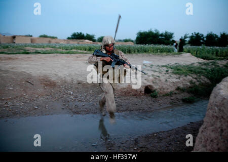 PATROL BASE SHARK, provincia di Helmand, Repubblica Islamica dell'Afghanistan - un fante con 3° Battaglione, 4° Reggimento Marine, salta su un piccolo flusso di acqua di recente. La combinata Anti-Armor squadre con l'unità frequentemente fare gite a diversi posti attorno alla loro area di operazioni sul ri-missioni di alimentazione. Anti-Armor rotoli, pattuglie attraverso la provincia di Helmand 110425-M-PE262-005 Foto Stock