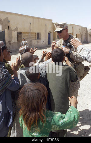 Lt. Col. Christian G. Cabaniss, comandante della 2° Battaglione, 8° Reggimento Marine, Regimental contro la squadra 3 penne a mano fuori per bambini locali nella città di Garmsir mentre la scorta della Forza internazionale di assistenza alla sicurezza vice comandante attraverso la città sett. 3, 2009. Forza internazionale di assistenza alla sicurezza vice incontra Garmsir governatore distrettuale DVIDS203626 Foto Stock