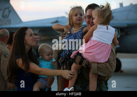 Michaela Winings, sinistra e i suoi tre bambini benvenuti home Capt. Nathan Winings al suo ritorno da una distribuzione con gli Stati Uniti Pacifico Comando al Marine Corps Air Station Cherry Point, Carolina del Nord, e il Agosto 9, 2015. Marine Tactical Electronic Warfare Squadron 2 restituito da una distribuzione a sostegno degli Stati Uniti Pacifico Comando. Lo squadrone fornito airborne electronic warfare nella regione Asia Pacifico nel corso di questa distribuzione. Winings è un EA-6B Prowler pilota con lo squadrone. (U.S. Marine Corps foto di Cpl. N.W. Huertas/RILASCIATO) VMAQ-2 home ha accolto a braccia aperte 150809 Foto Stock