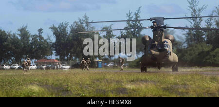 Marines rush al di fuori di un CH-47 Chinook esercito elicottero a zona di atterraggio gufo, dando dei calci fuori esercizio congiunto isola Fury a bordo Marine Corps Area Formazione soffietto, Hawaii, 26 ottobre, 2015. I soldati trasportati i Marines durante il giorno e uno di JEIF da Marine Corps base Hawaii per MCTAB. Quattro giorni di esercizio servizio coinvolge membri provenienti da tutti i rami del militare tra cui la Guardia Costiera. I membri del servizio sarà condotta risposta in caso di crisi, sicurezza, umanitario e le operazioni di soccorso durante l'esercizio. III Marine Expeditionary fornisce le forze degli Stati Uniti con un forward-forza dispiegata in readin Foto Stock