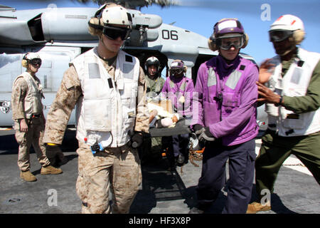 Marines e velisti assegnati per il ventiquattresimo Marine Expeditionary Unit e il Nassau anfibio gruppo pronto portare un due-anno-vecchio figlio di Haiti da un MH-60 Sea Hawk elicottero durante un'emergenza medivac. Quattro cittadini haitiani, due uomini e due bambini sono stati medivaced dai militari di comando Sealift nave ospedale USNS Comfort all'assalto anfibio nave USS Nassau dove hanno ricevuto ulteriore assistenza medica. Un maschio adulto è in condizioni critiche, l'altra è in condizione stabile. Il due-anno-vecchio figlio è in condizione stabile e un infante non hanno evidenti ferite. Nassau e la ventiquattresima MEU ar Foto Stock