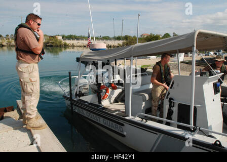 GUANTANAMO Bay a Cuba - Guardia Costiera Controlman danni di terza classe Kyle Thompson, Guardia costiera di Boatswain Mate 3° di classe Michael Walker e Guardia Costiera di Boatswain mate 1. Classe Jason Dyer, tutti distribuiti per la sicurezza marittima e il Team di Sicurezza di 91103 a sostegno della Joint Task Force Guantanamo, goccia una barca nelle acque della baia di Guantanamo, 22 febbraio, 2010. MSST 91103 è distribuito qui per eseguire maritime anti-terrorismo e vigore dazi di protezione per JTF Guantanamo. JTF Guantanamo conduce al sicuro, umano, legale e trasparente di cura e custodia dei detenuti, compresi quelli condannati dalla commissione militare di un Foto Stock