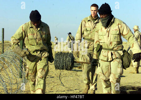 030217-M-3692W-077 Camp Bullrush, Kuwait (feb. 17, 2003) -- Lancia Cpl. Eric Sally e Lance Cpl. Nabor Alvarado, ingegneri di combattimento con il XV Marine Expeditionary Unit (Operazioni speciali in grado) srotolare il filo spinato lungo il loro campo perimetro di sicurezza. I marines sono dispiegati in Kuwait a sostegno dell'Operazione Enduring Freedom. Stati Uniti Marine Corps photo by Lance Cpl. Brian L. Wickliffe. (Rilasciato) Navy US 030217-M-3692W-077 Lancia Cpl. Eric Sally e Lance Cpl. Nabor Alvarado, ingegneri di combattimento con il quindicesimo Marine Expeditionary Unit (Operazioni speciali in grado) Foto Stock