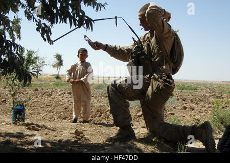 Lancia Cpl. Allen Murphy, un operatore radio con Sniper plotone, Lima Company 3° Battaglione 7° Reggimento Marine, Regimental Combat Team 2, dà il cibo ad un ragazzo afghano durante 14 giorni di funzionamento 20 Maggio in Washir, Afghanistan. I marines condotta giorno e notte pattuglie di sicurezza per lottare contro qualsiasi insurrezione nella zona. (Foto: Lance Cpl. Eugenio Montanez) Lima Company, cecchini, portata fuori Washir DVIDS284273 Foto Stock