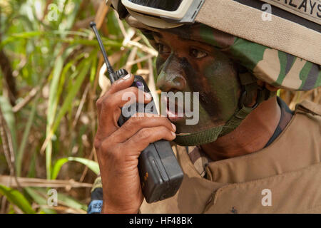 100727-M-2339L-2698 KAHUKU AREA FORMAZIONE, Hawaii (Luglio 27, 2010) - un paracadutista malese con 9 Royal Reggimento Malay, malese esercito, mantiene la comunicazione con il suo plotone durante un raid in elicottero su una improvvisata dispositivo esplosivo fabbrica con U.S. Marines dalla società e, secondo battaglione, 3° Reggimento Marine, a Kahuku Area Formazione, Hawaii, luglio 27. Il raid è stato l'azione successiva ad una evacuazione noncombatant operazione eseguita da 2/3 Marines e le forze della coalizione a Marine Corps Area Formazione soffietto, Hawaii, luglio 26. Entrambe le operazioni sono state condotte come parte della formazione di interoperabilità b Foto Stock