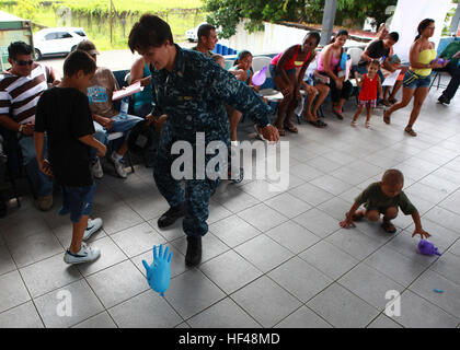 Stati Uniti Navy Lt. Janette Arencibia, avviato con USS Iwo Jima (LHD-7). L'operazione continua promessa 2010, calci un gonfiato guanto medico con una Costa Rican ragazzo in un sito medico in Limon Costa Rica, 22 agosto I membri del servizio e i civili sono distribuiti a supporto di CP la fornitura di assistenza umanitaria e di soccorso in caso di catastrofe per i Caraibi, America Centrale e Sud America. L'operazione continua promessa 2010 DVIDS312125 Foto Stock