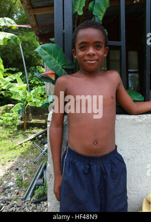 Una Costa Rican boy orologi come elementi di servizio di lavorare su una scuola attraversata la strada dalla sua casa di Limon Costa Rica, e il agosto 23. Stati Uniti Marines e marinai sono la costruzione di recinzioni, versando le fondamenta e pittura presso una scuola a sostegno di CP. L'operazione continua promessa 2010 DVIDS312129 Foto Stock