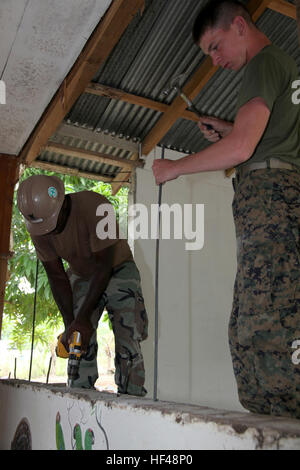 Pfc. Donald L. Cunningham, nativo di De Kalb Junction., N.Y., e di bulk specialista del carburante con 8 Supporto tecnico di battaglione della logistica elemento di combattimento di Marine dedicate Air-Ground Task Force promessa continua 2010, martelli rebar dopo Navy combattere Warfare Specialist 2a classe Randall L. Johnson, nativo di Kansas City, Mo., trapani fori nel cemento durante i lavori di costruzione di un ingegnere presso il Centro di Educazione e nutrizione in Bribri, Costa Rica, 24 agosto 2010. Marines e Navy Seabees previsti lavori di costruzione di un ingegnere sito per aiutarti a Costa Rica durante il CP10. Marines, marinaio Foto Stock