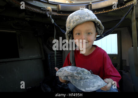 Quattro-anno-vecchio Syxx Bullplume di Tacoma, nello Stato di Washington si trova all'interno di un Humvee con un casco sulla sua testa e una pattuglia con il cappello in mano, Sett. 25 con il Lakewood Towne Center durante la 'saluta Lakewood." soldati con 4° Stryker Brigade Combat Team, seconda divisione di fanteria fornita una visualizzazione statica di humvees e lasciata la gente del posto a salire all'interno e provare a combattere la marcia e insegnato la gente circa le funzionalità e gli scopi di humvees. Flickr - DVIDSHUB - 'saluta Lakewood' celebra gli eroi locali Foto Stock