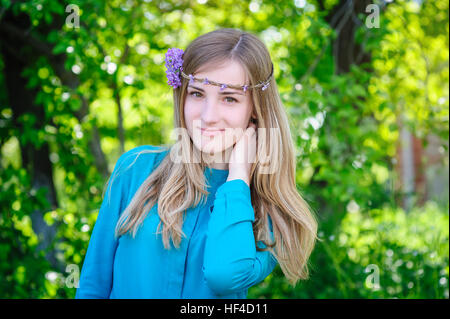 Giovane bella donna con la corona sulla sua testa di passeggiate nel parco di estate Foto Stock