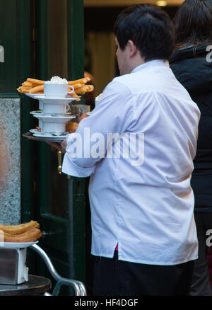 Cameriere a cioccolateria San Gines ristorante famoso per i churros con cioccolata, nel centro di Madrid. Spagna. Foto Stock