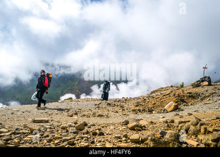 Due persone si arrampicano sul pendio della caldera vulcanica del Monte Papandayan. Giava Occidentale, Indonesia. Foto Stock