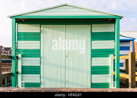 Inghilterra, Whitstable. Beach Hut sul lungomare, dipinta in due tonalità di verde, bloccato. Vista frontale. Foto Stock