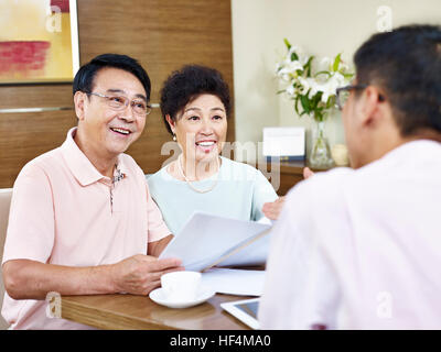 Senior asian giovane ascoltare la spiegazione da parte di un rappresentante di vendita, felice e sorridente. Foto Stock