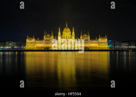 Il punto di vista del Parlamento ungherese edificio accanto Fiume Danubio a Budapest, Ungheria durante la notte. Foto Stock