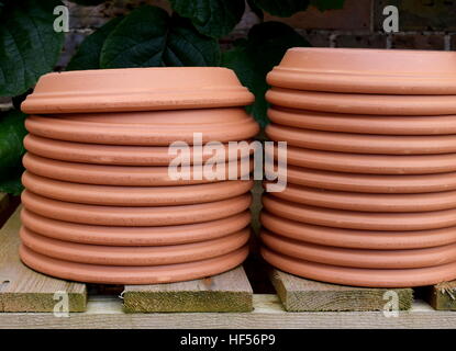 Pila di terracotta capovolta giardino piattini sul ripiano di legno Foto Stock