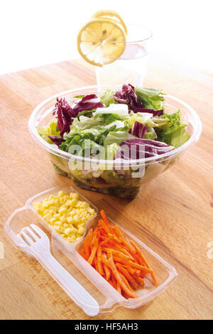 Il pranzo per andare: radicchio, insalata verde, formaggio, pezzi di carota, acqua minerale e le posate di plastica Foto Stock