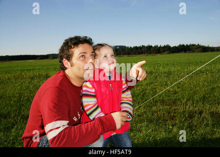 Il padre e i suoi tre-anno-vecchio figlia giocando con un aquilone Foto Stock