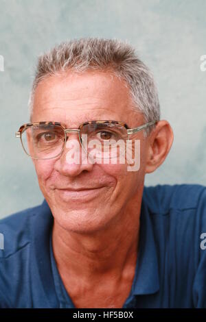 Uomo anziano con gli occhiali seduto di fronte a una casa a Cienfuegos, Cuba, Caraibi, America Foto Stock