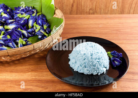 Riso blu cucinare da Butterfly fiore di pisello (Clitoria ternatea L) nel piatto nero. Il riso è un colorati e profumati fiori e buona per la salute. Foto Stock