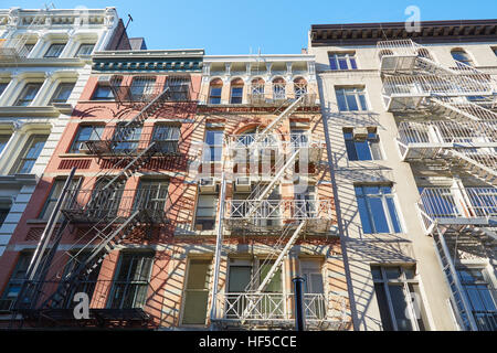 Facciate di case con scale antincendio, giornata di sole a Soho, New York Foto Stock