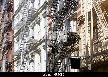 Facciate di case con scale antincendio, giornata di sole a Soho, New York sullo sfondo Foto Stock